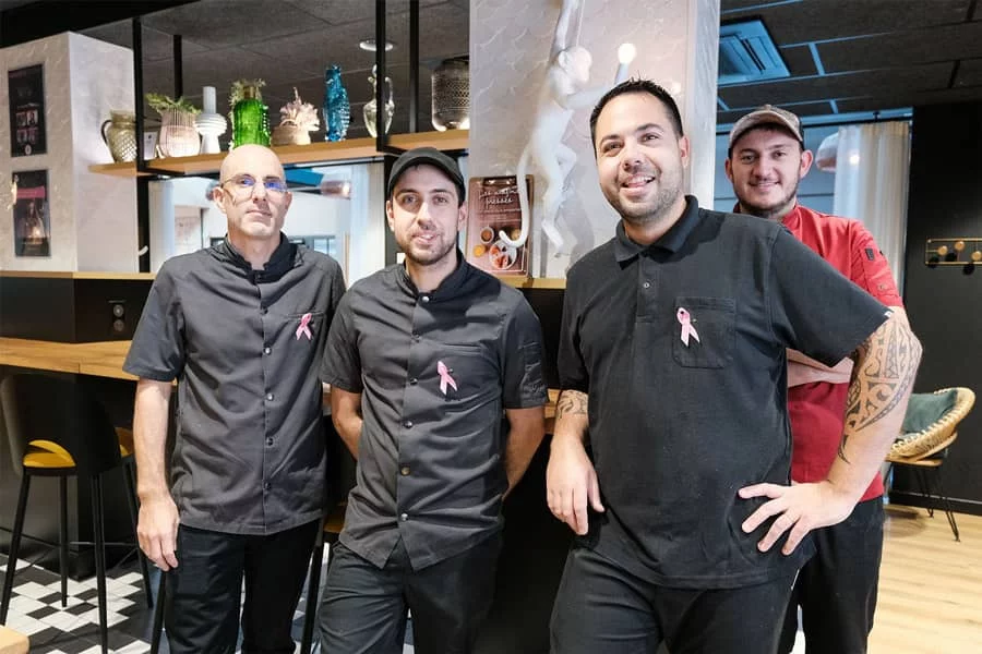 Collaborateurs du Monkey Place portant un badge Octobre Rose à La Roche-sur-Yon en soutien à la lutte contre le cancer du sein en 2024